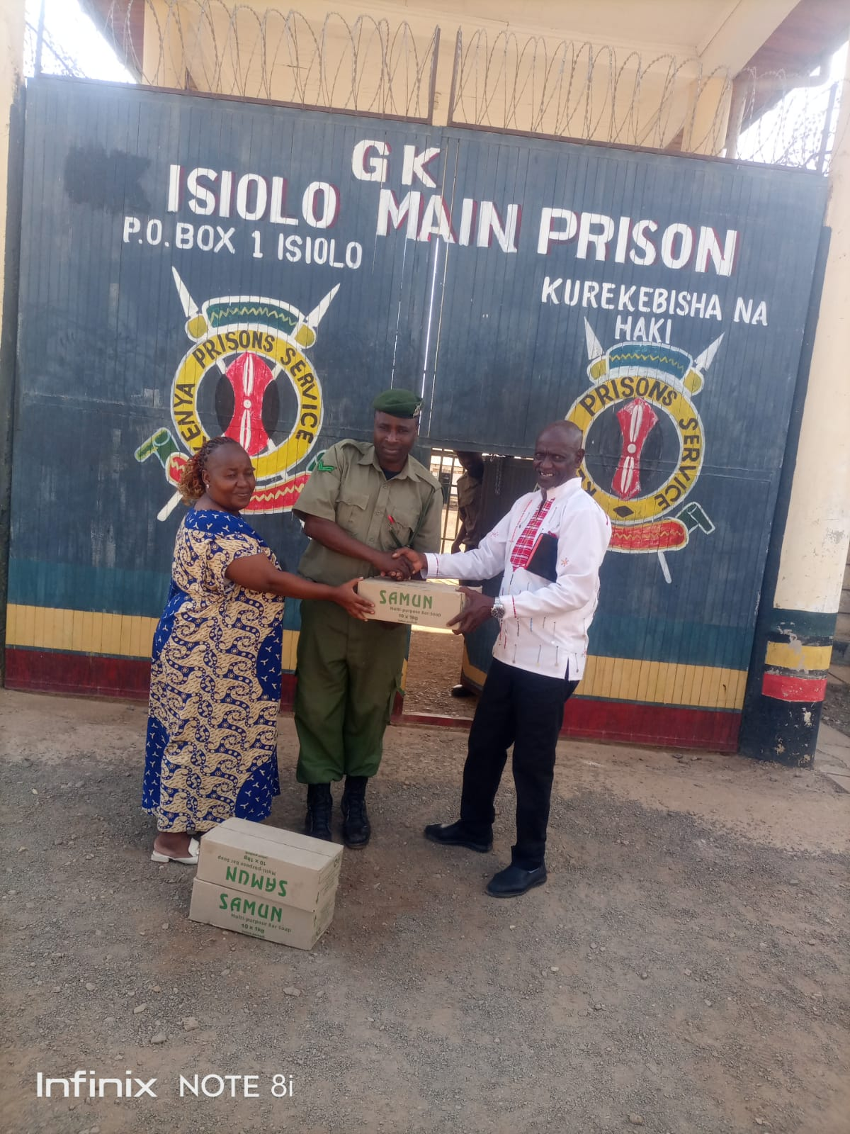 G.K. Isiolo Main Prison — Pastor David hands over the soap consignment to the officer in charge.